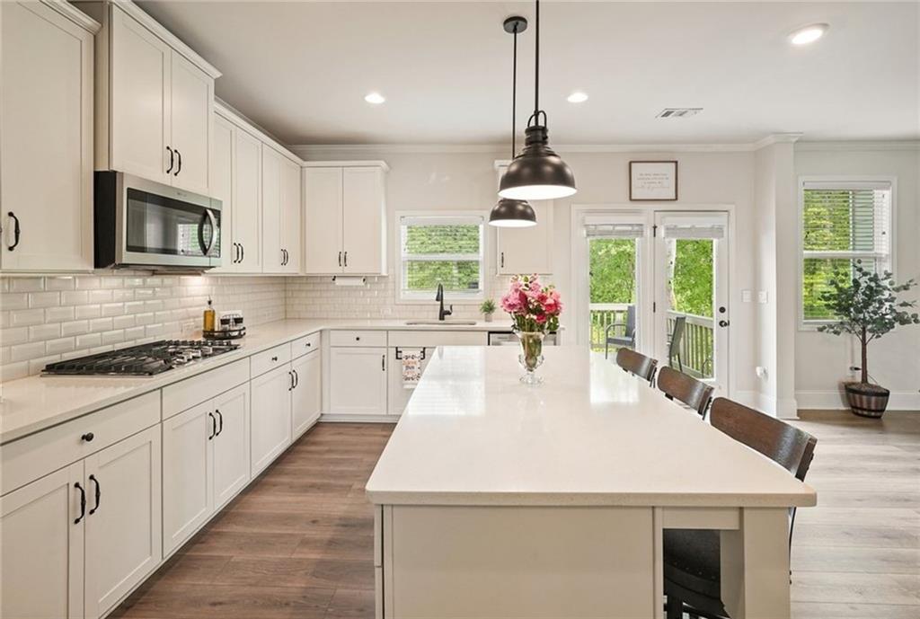 6915 Rambling Vale Dawsonville, GA 30534 - Photo 19 of 63 a large white kitchen with stainless steel appliances granite countertop a stove a sink a microwave and a refrigerator