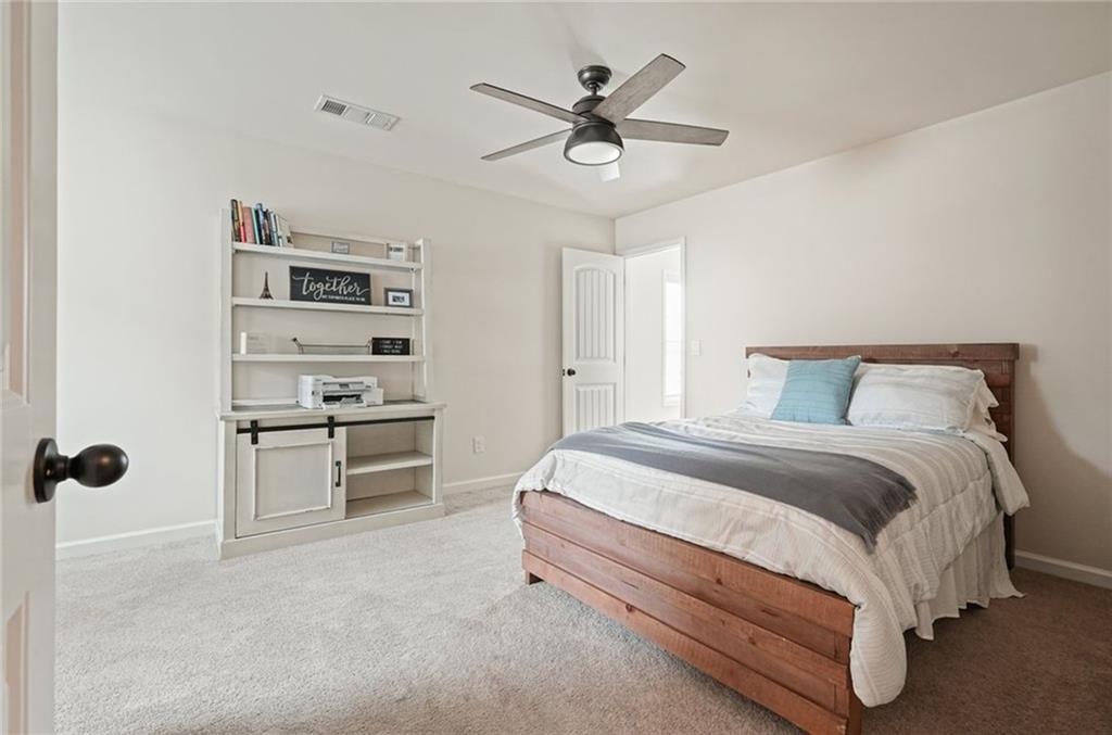 6915 Rambling Vale Dawsonville, GA 30534 - Photo 25 of 63 a spacious bedroom with a bed and a ceiling fan
