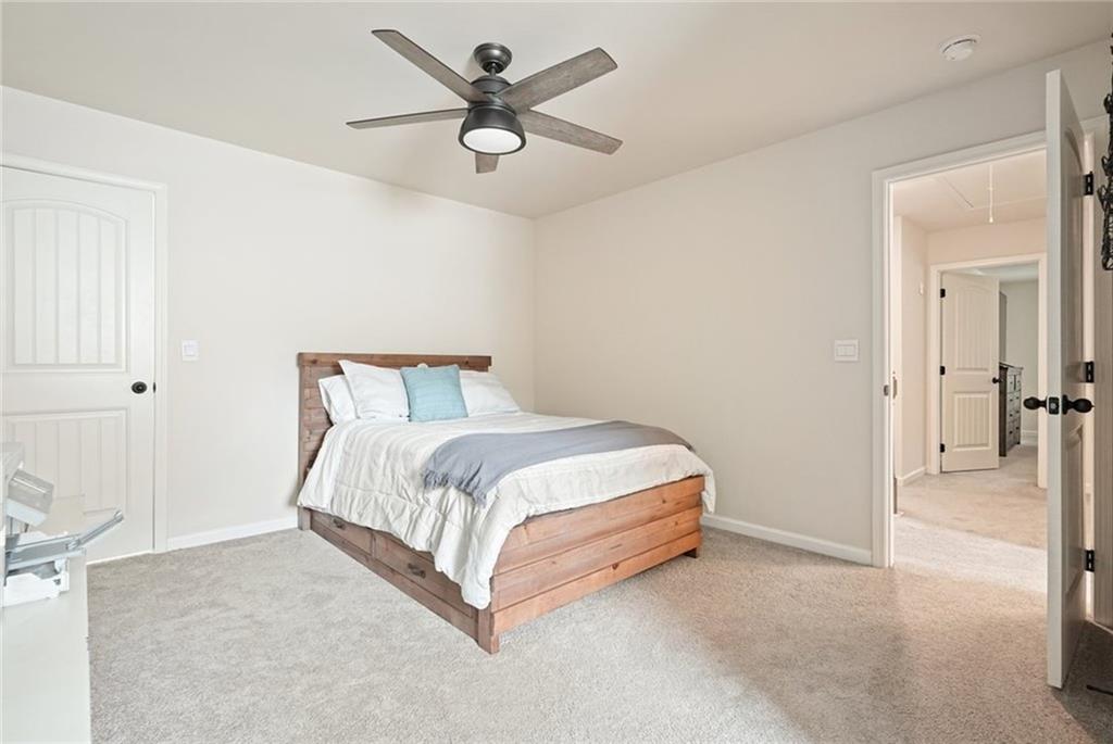 6915 Rambling Vale Dawsonville, GA 30534 - Photo 27 of 63 a spacious bedroom with a bed and a chandelier