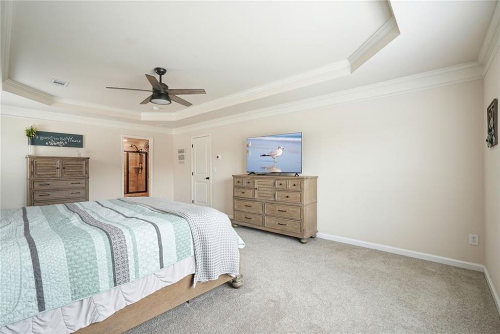 6915 Rambling Vale Dawsonville, GA 30534 - Photo 38 of 63 a bedroom with a bed a dresser and a chandelier