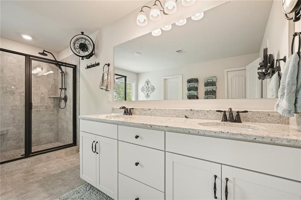 6915 Rambling Vale Dawsonville, GA 30534 - Photo 40 of 63 a bathroom with a granite countertop sink mirror and shower