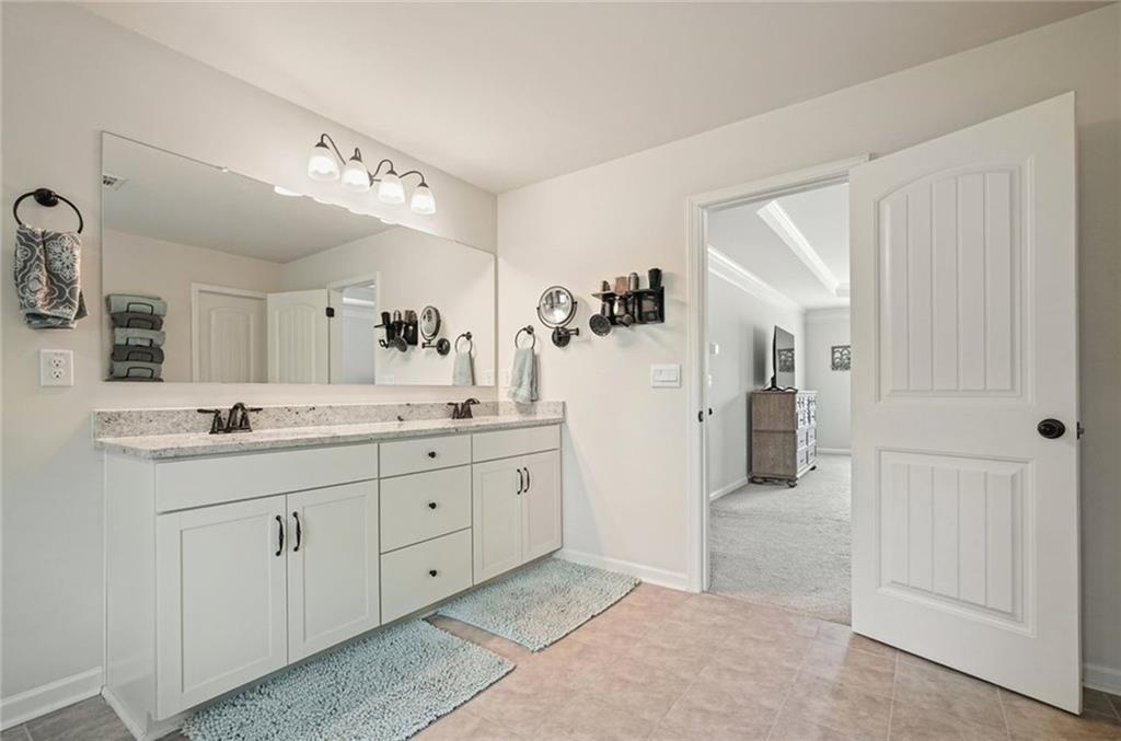 6915 Rambling Vale Dawsonville, GA 30534 - Photo 41 of 63 a spacious bathroom with a granite countertop sink a mirror and shower