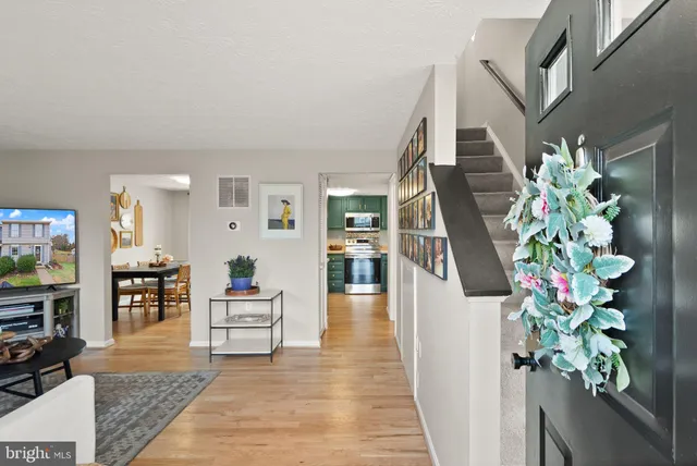 a hallway with wooden floor stairs and furniture