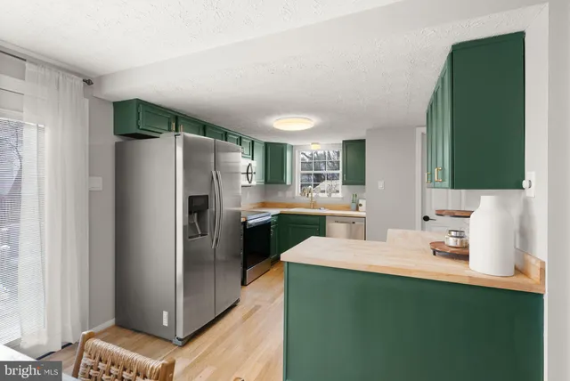 a kitchen with kitchen island a refrigerator sink and stove