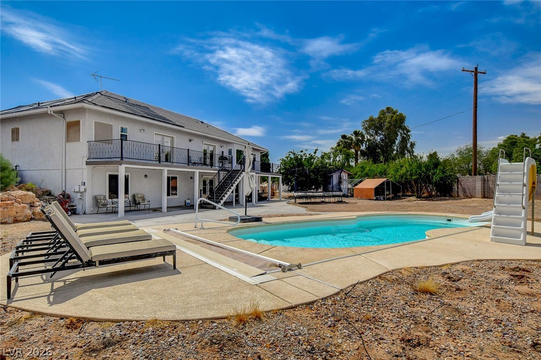 4362 Thistle Street Logandale, NV 89021 - Photo 80 of 99 An inviting backyard oasis awaits with a sparkling pool, slide, and ample space for lounging.