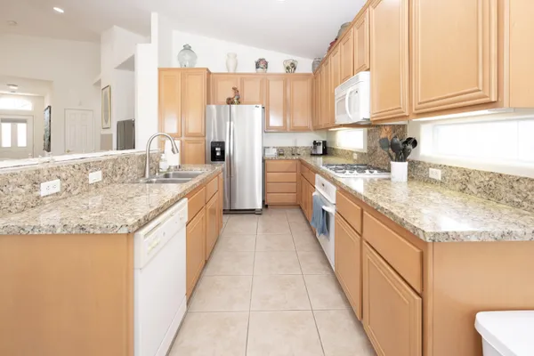 a large kitchen with granite countertop a sink stainless steel appliances and a cabinets