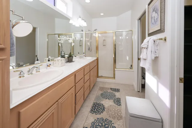 a bathroom with a double vanity sink mirror and shower