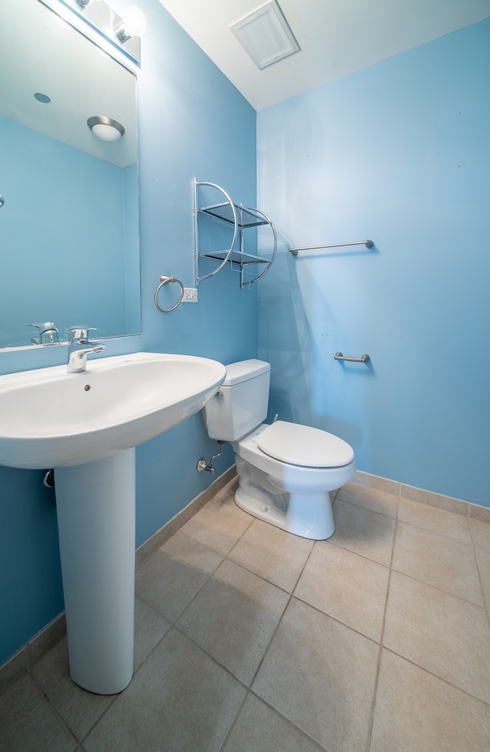 1720 South Michigan Avenue, Unit 2512 Chicago, IL 60616 - Photo 12 of 18 a bathroom with a sink toilet and mirror