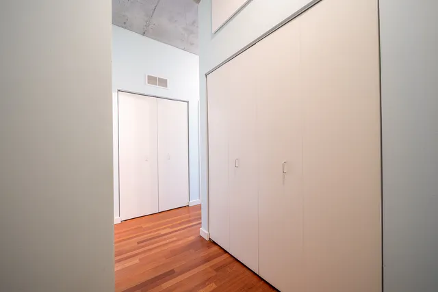 an empty room with wooden floor and entrance