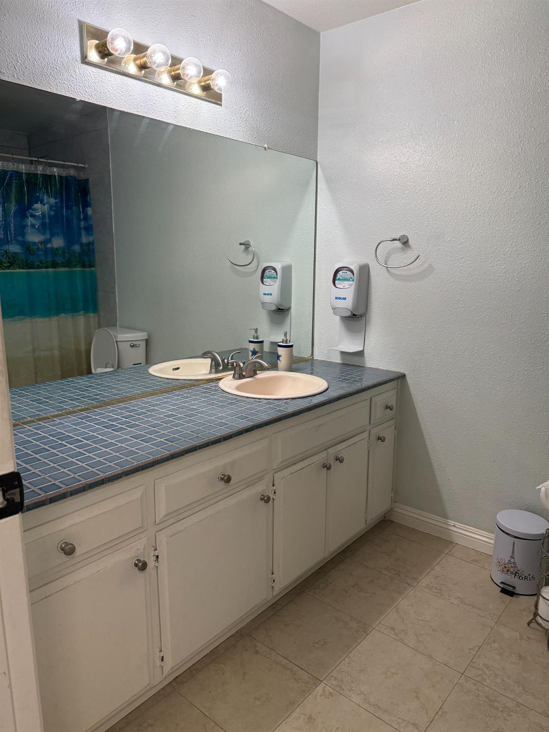 1508 Mable Avenue Modesto, CA 95355 - Photo 20 of 25 a spacious bathroom with a granite countertop sink a toilet and a mirror
