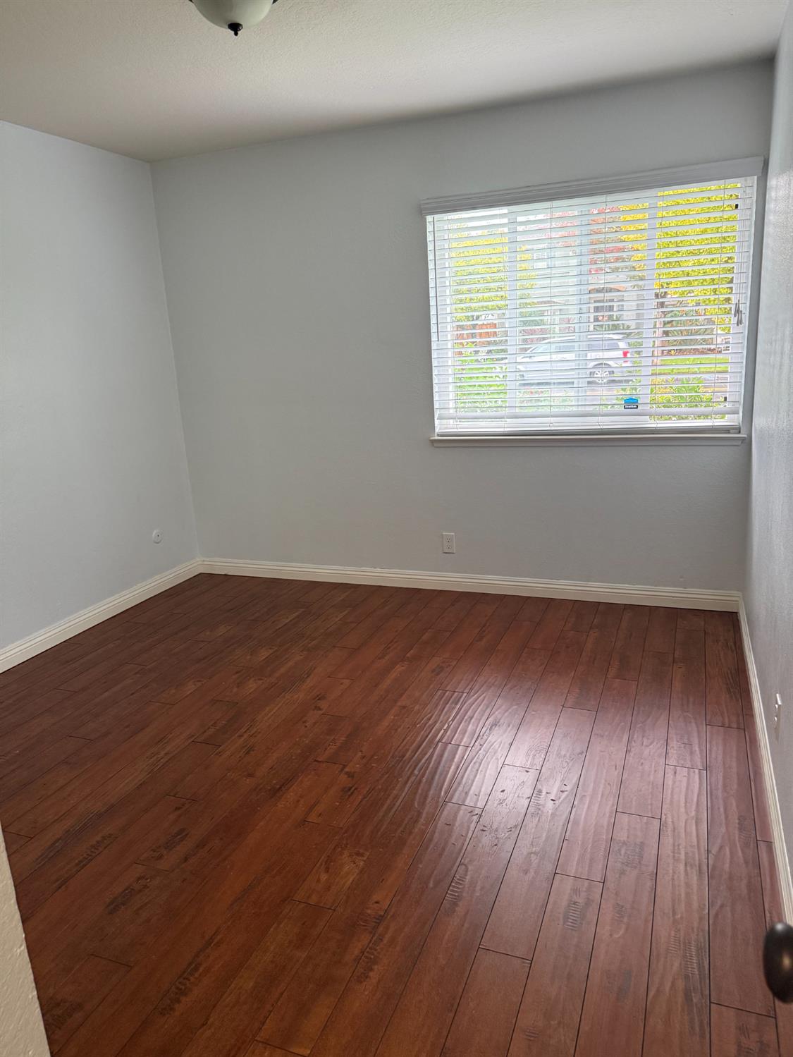 1508 Mable Avenue Modesto, CA 95355 - Photo 21 of 25 a view of an empty room with wooden floor and a window
