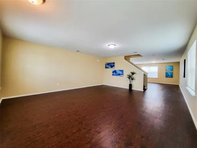a view of a livingroom with wooden floor and stairs