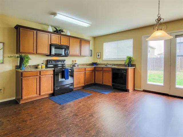 a kitchen with stainless steel appliances granite countertop wooden floors and white cabinets