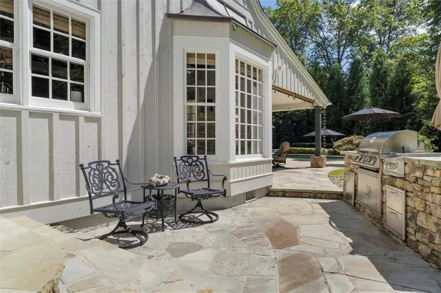 a view of a dining room and livingroom with furniture wooden floor a chandelier