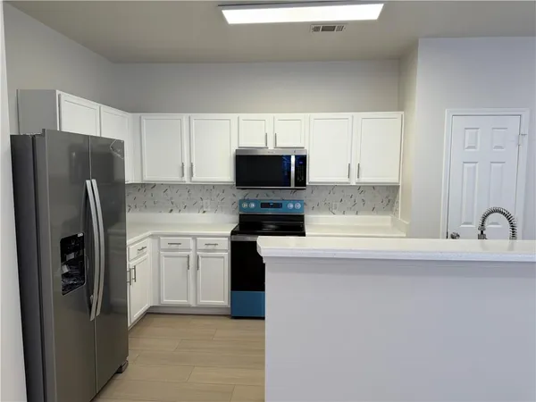 a kitchen with stainless steel appliances a refrigerator stove and sink