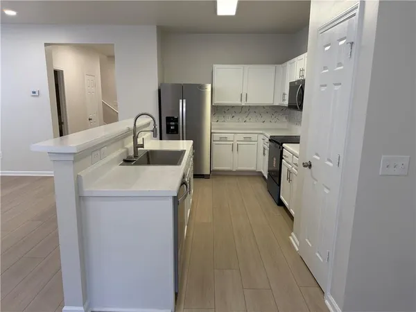 a kitchen with a sink stove and refrigerator