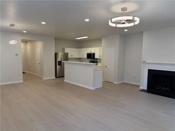 a view of a kitchen with a sink stove cabinets and entryway
