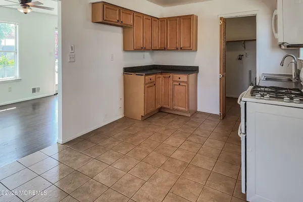a kitchen with granite countertop a stove a sink and a refrigerator
