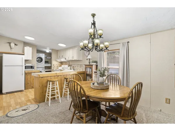 a view of a dining room with furniture a chandelier and wooden floor