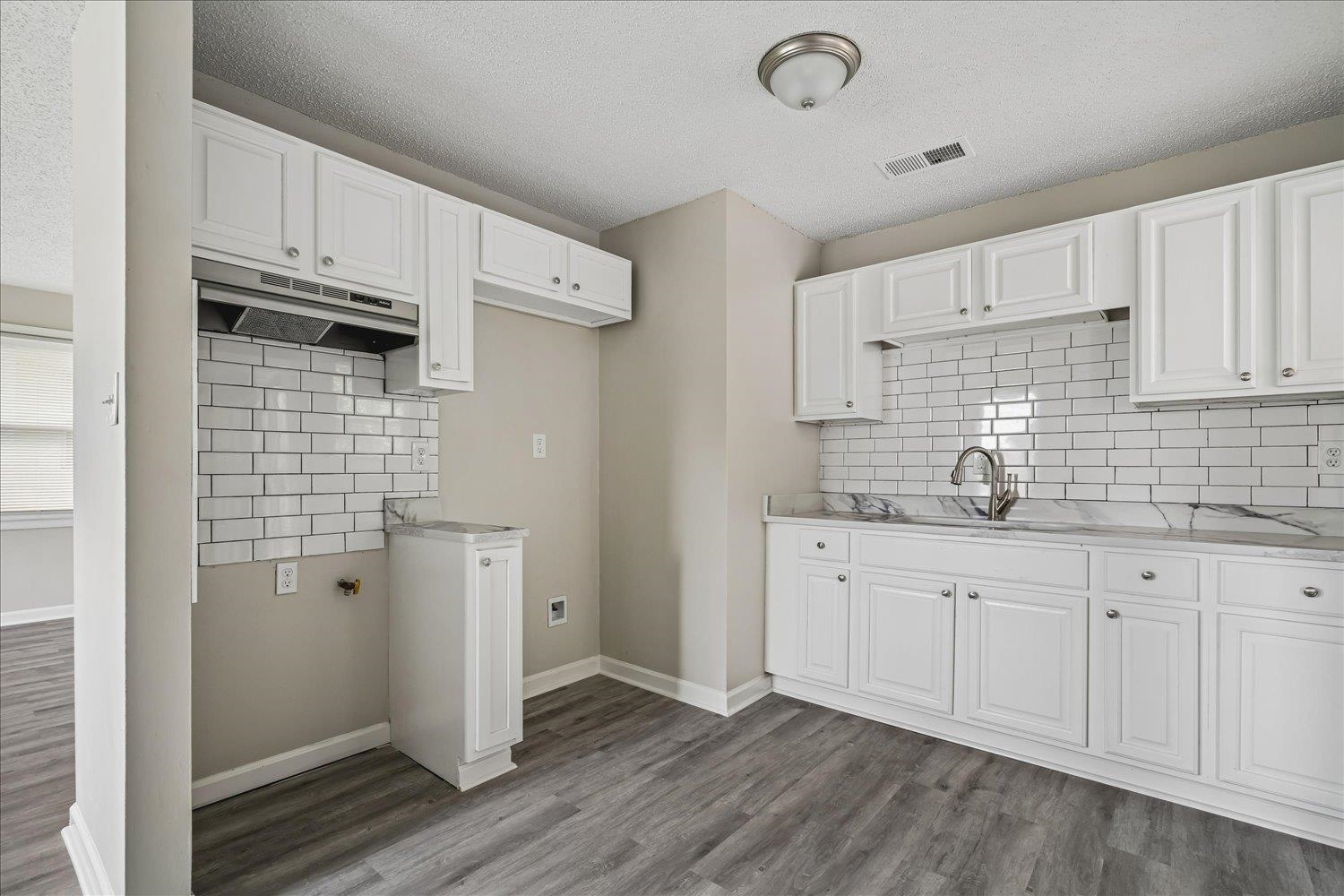 2518 Manchester Road Memphis, TN 38114 - Photo 2 of 23 Kitchen featuring white shaker-style cabinetry, a subway tile backsplash, and a sink with a gooseneck faucet