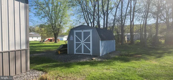 a view of backyard with wooden fence and a large tree