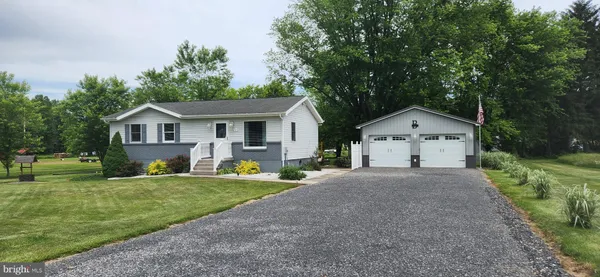 a front view of a house with a yard and trees