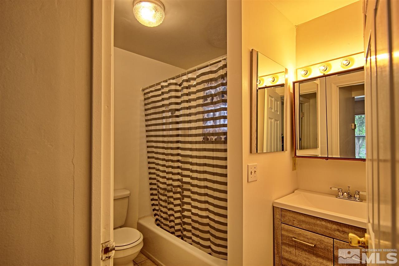4575-4571 Alcorn Road Fallon, NV 89406 - Photo 23 of 25 a bathroom with a toilet and a shower curtain
