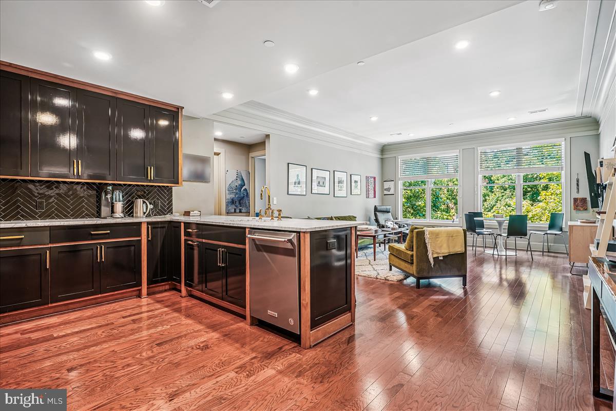 1301 H Street Northeast, Unit 2 Washington, DC 20002 - Photo 12 of 36 a kitchen with stainless steel appliances granite countertop a stove top oven and a dining table with wooden floor