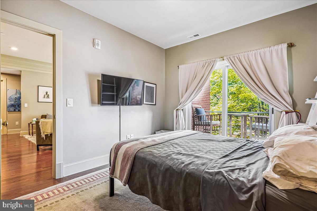 1301 H Street Northeast, Unit 2 Washington, DC 20002 - Photo 16 of 36 a bedroom with a bed a flat screen tv and a large window