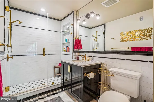 a bathroom with a sink vanity mirror and toilet