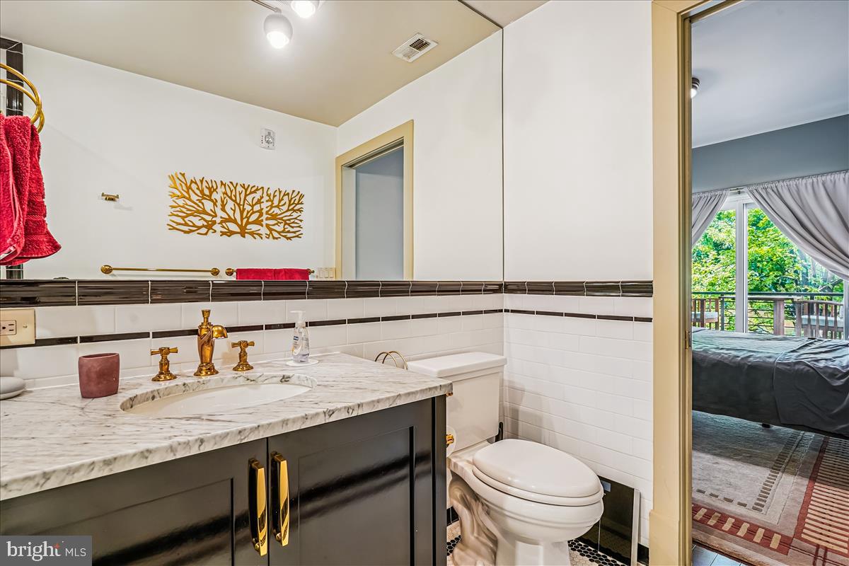 1301 H Street Northeast, Unit 2 Washington, DC 20002 - Photo 18 of 36 a bathroom with a granite countertop toilet sink and mirror