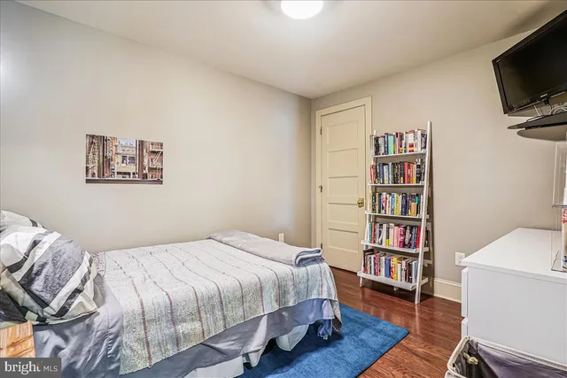 a bedroom with a bed a book shelf and a window