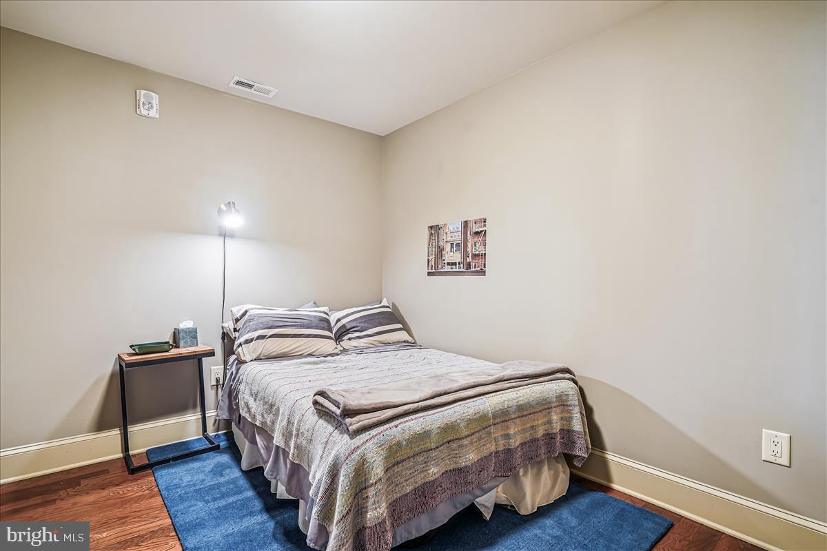 1301 H Street Northeast, Unit 2 Washington, DC 20002 - Photo 24 of 36 a bedroom with a bed and wooden floor