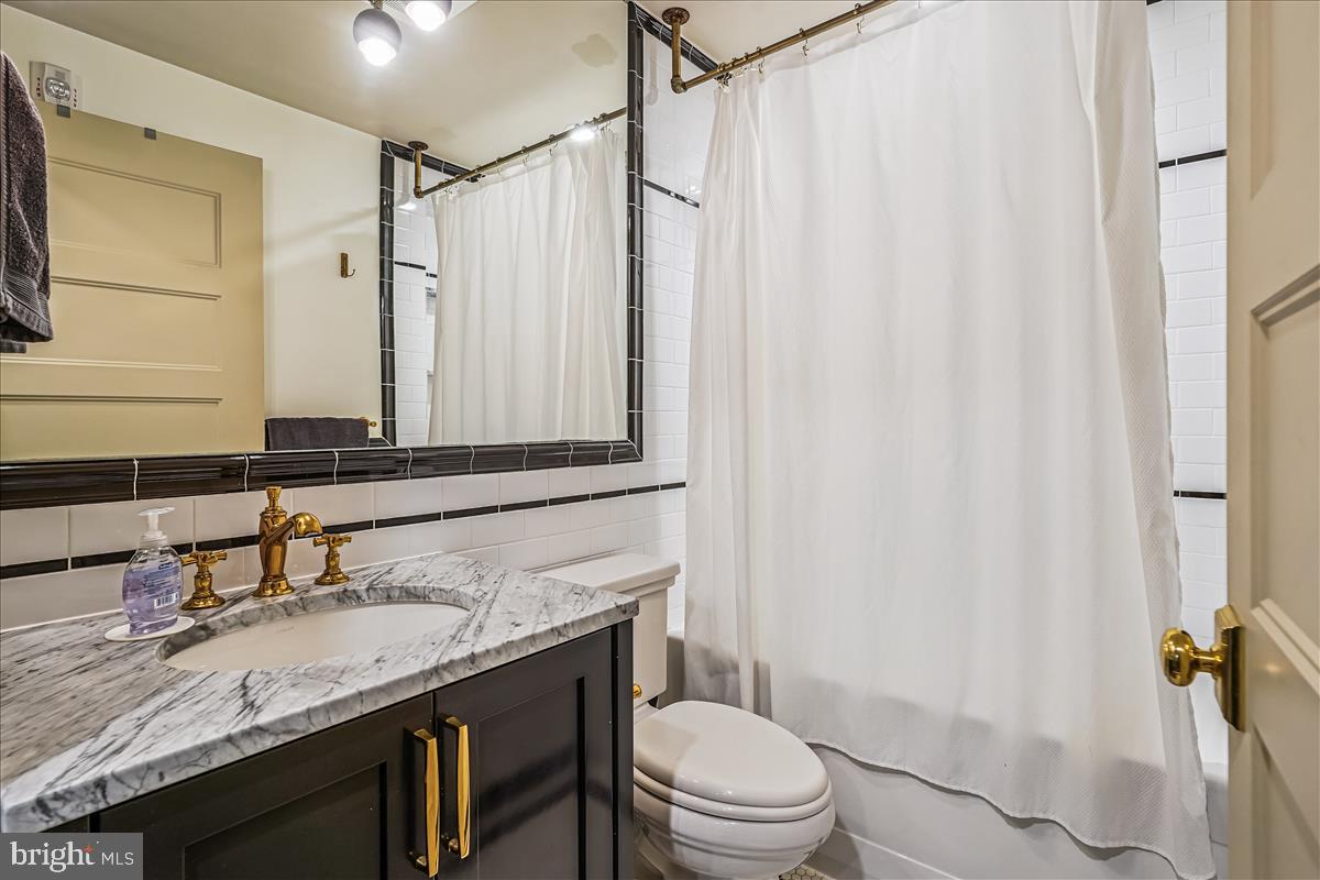1301 H Street Northeast, Unit 2 Washington, DC 20002 - Photo 26 of 36 a bathroom with a granite countertop sink toilet and shower