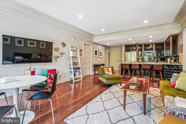 a living room with furniture a flat screen tv and kitchen view