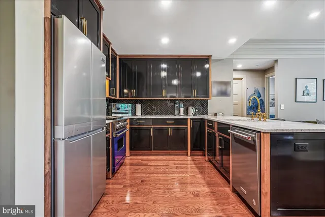 a kitchen with stainless steel appliances granite countertop a refrigerator and a sink