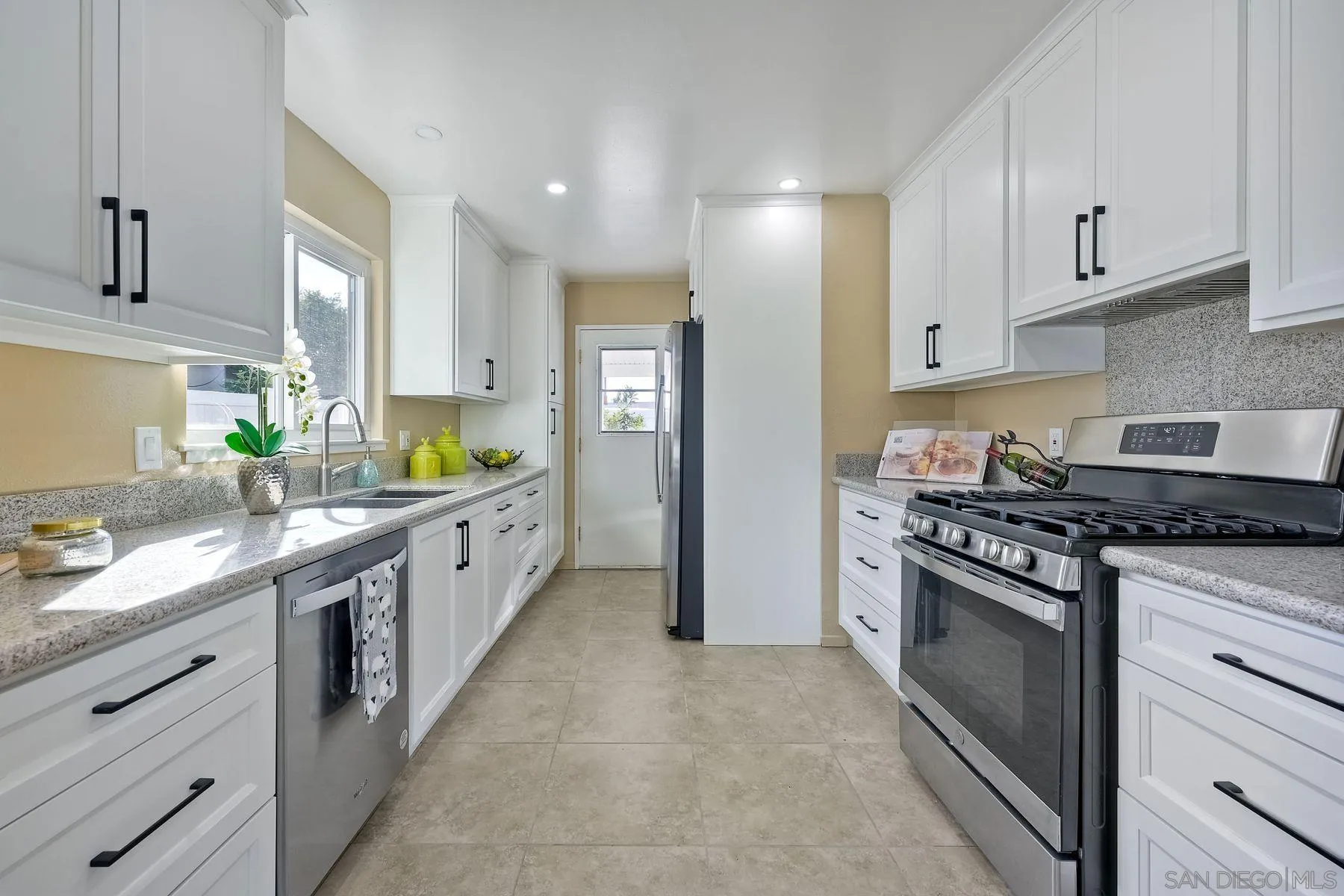 4472 Rolfe Road San Diego, CA 92117 - Photo 1 of 23 a large kitchen with stainless steel appliances granite countertop a stove and a sink