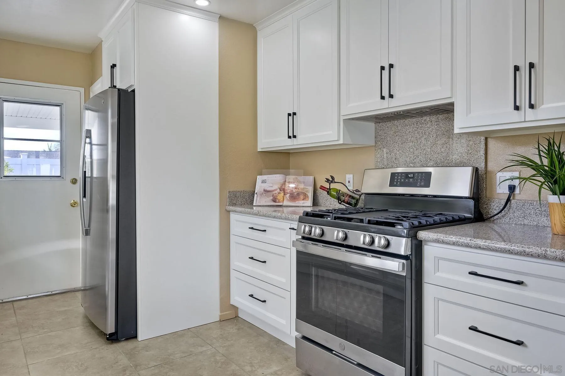 4472 Rolfe Road San Diego, CA 92117 - Photo 10 of 23 a kitchen with granite countertop white cabinets and stainless steel appliances