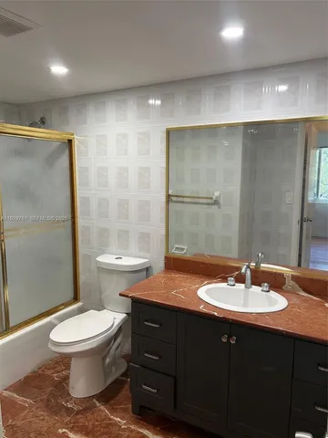 a bathroom with a double vanity sink toilet and shower