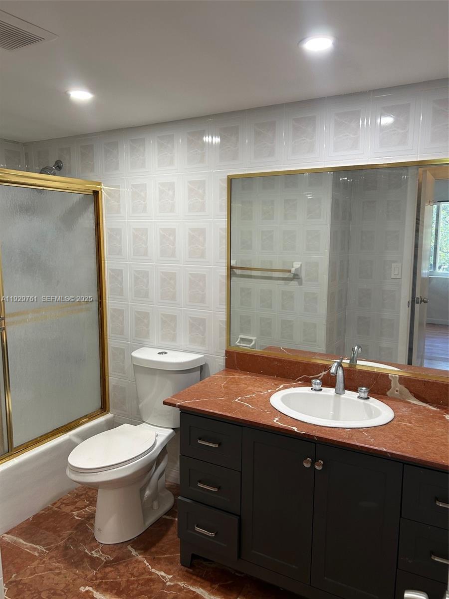 2201 Brickell Avenue, Unit 29 Miami, FL 33129 - Photo 6 of 9 a bathroom with a double vanity sink toilet and shower
