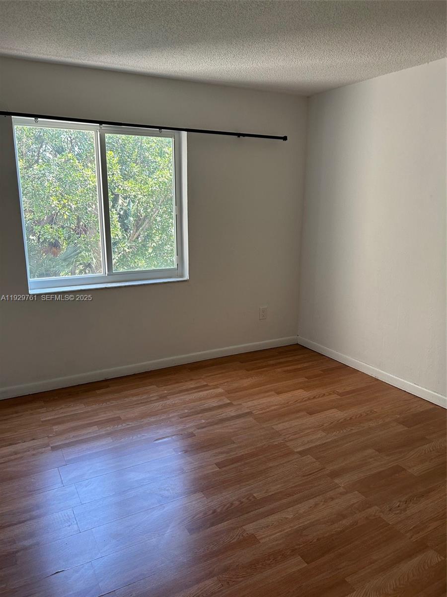 2201 Brickell Avenue, Unit 29 Miami, FL 33129 - Photo 7 of 9 a view of an empty room with wooden floor and a window