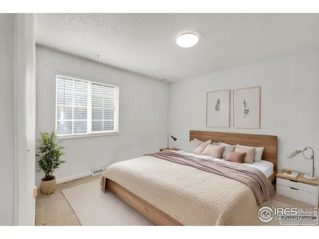 a bedroom with a large bed and a potted plant