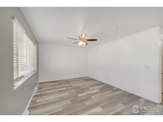 a view of a living room with a ceiling fan and hardwood floor