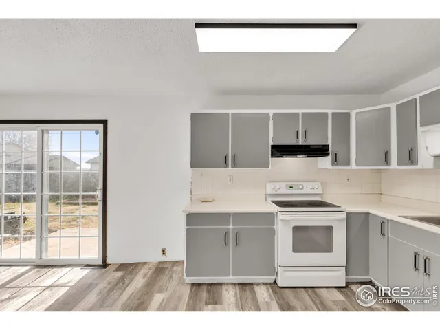 a kitchen with a stove and white cabinets