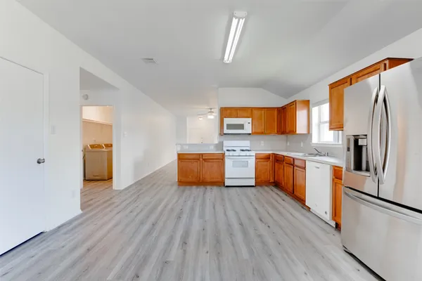 a large kitchen with a wooden floor and stainless steel appliances
