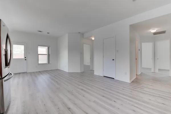 an empty room with wooden floor and mirror
