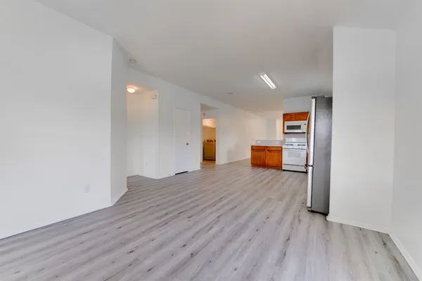 a big room with wooden floor and a window