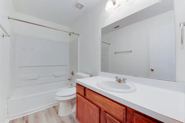 a bathroom with a sink toilet vanity and shower