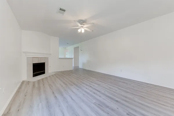 a view of empty room with wooden floor and fireplace