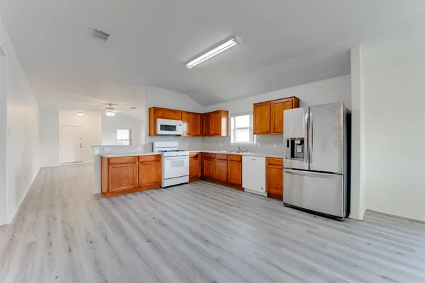 a kitchen with stainless steel appliances wooden floor a refrigerator and a stove